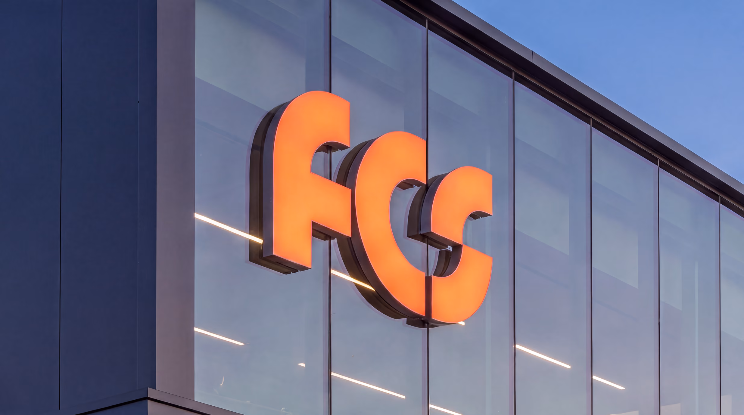 Leuchtendes FCS-Zeichen an der Glasfassade von Frenkel Chemical Solutions